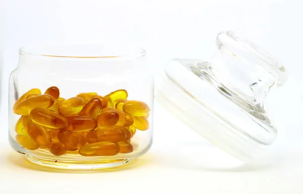 Huile de foie de morue oméga 3 capsules de gel de vitamine e isolées sur fond blanc dans une bouteille en verre transparent avec couvercle en verre — Photo