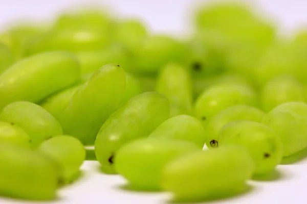 Uva verde sem ramos e folhas isoladas em branco. Com o caminho de recorte. Fechar macro e profundidade de campo rasa . — Fotografia de Stock