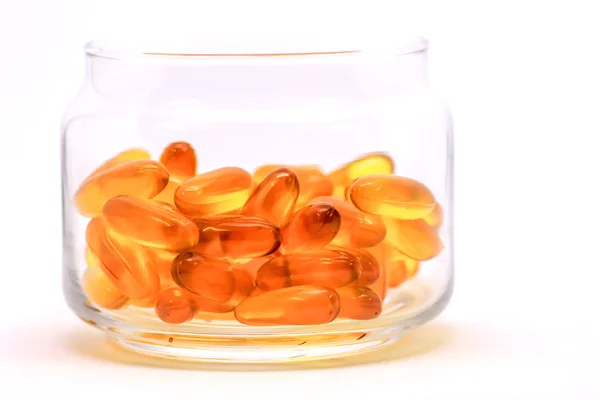 Kabeljaufleberöl Omega-3-Vitamin-E-Gel-Kapseln isoliert auf weißem Hintergrund in einer transparenten Glasflasche lizenzfreie Stockfotos
