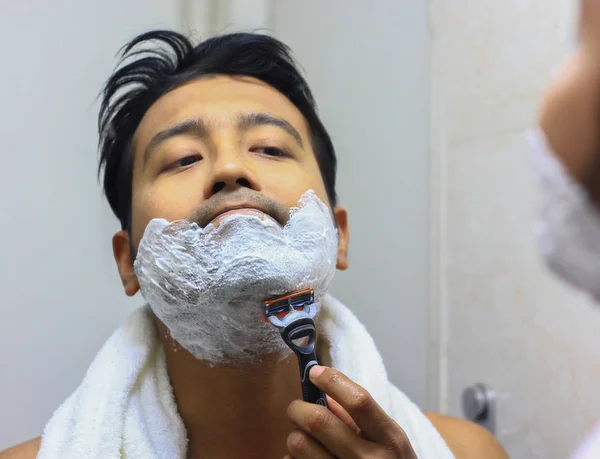 Man looking after his appearance in front of a mirror beauty styling lifestyleman lookingIndian asian after his appearance in front of a mirror beauty styling lifestyle. Shaving routine — Stock Photo, Image