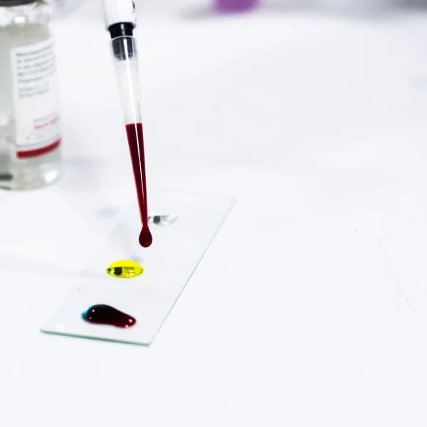 Gota de sangre en el portaobjetos de vidrio para la agrupación de la sangre usando micro punta — Foto de Stock