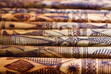 el yapımı ahşap bambu bambu, oyulmuş bambu sopalarla satırlarının üzerinde oyulmuş balık resim sanat oyma. dokulu arka plan. kabile sanat.
