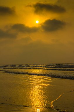 Altın gündoğumu günbatımı twilight saat. Güneş ışınları üzerinde deniz su ve shore.vertical yönlendirme yansıtan