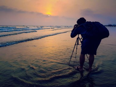 Bir bagpack bir fotoğrafçı ile gündoğumu fotoğraf çekerken bea