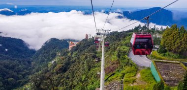 cable car at genting highlands, malaysia in a foggy weather with green grass visible from inside cable car