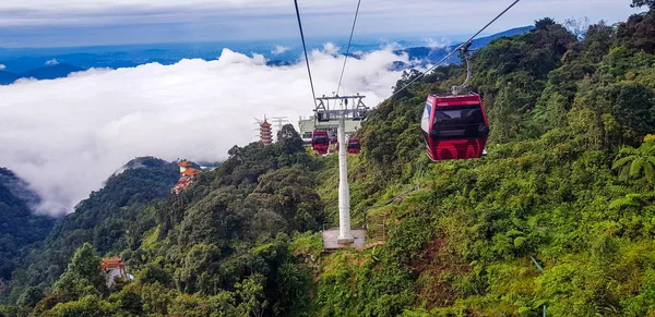 cable car at genting highlands, malaysia in a foggy weather with green grass visible from inside cable car