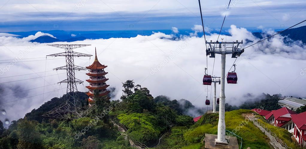 cable car at genting highlands, malaysia in a foggy weather with chin swe chinese temple visible from inside cable car