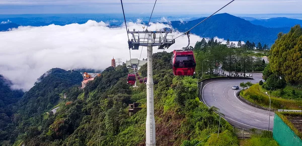 cable car at genting highlands, malaysia in a foggy weather with green grass visible from inside cable car