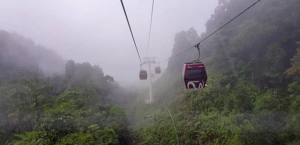 Teleférico en las tierras altas de genting, Malasia en un tiempo nebuloso con hierba verde visible desde el interior teleférico — Foto de Stock