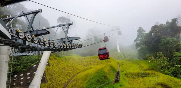 Teleférico en las tierras altas de genting, Malasia en un tiempo nebuloso con hierba verde visible desde el interior teleférico — Foto de Stock