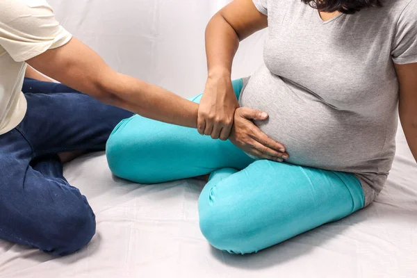 El cuerpo disparado de una mujer embarazada con la mano con las manos del marido en el vientre — Foto de Stock
