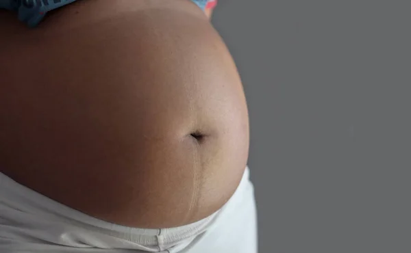 Vientre de una mujer embarazada con enfoque en el abdomen — Foto de Stock