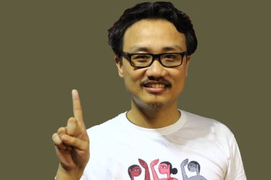 Gülümseyen ve kendinden emin bir manipuri Kuzeydoğu Hindistanlı gözlüklü, parmakları olan bir adamın işaretini gösteriyor.