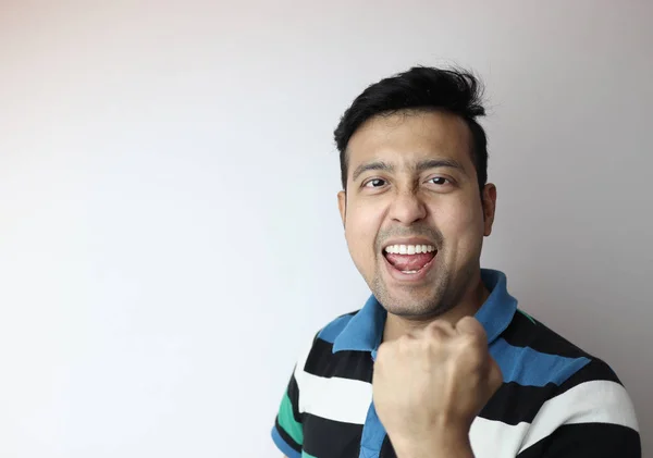 Oh, sí. cara de un hombre asiático con el puño cerrado mostrando expresión encantada con un espacio de copia con fondo gris . — Foto de Stock