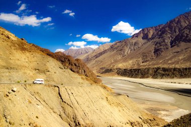Hindistan 'da, ladakh, Jammu ve Kashmir' de, derin mavi gökyüzü ve beyaz yamalı bulutları olan çöldeki çorak dağın yüksek dinamik aralıklı görüntüsü.