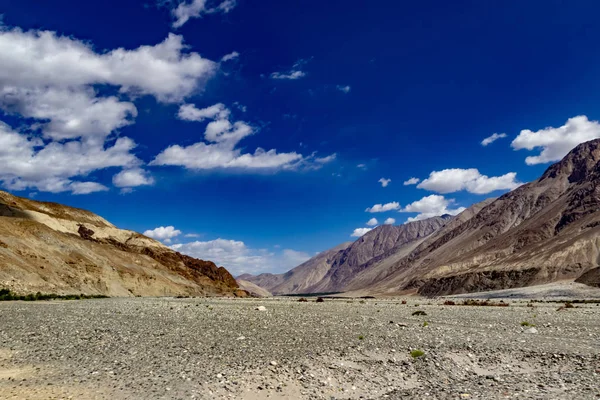 Manzara, kayalık çakıl taşlarının ön planında parlak mavi gökyüzünü ve ladakh, Kashmir, Hindistan 'ın çorak kuru dağlarını gösteriyor. — Stok fotoğraf