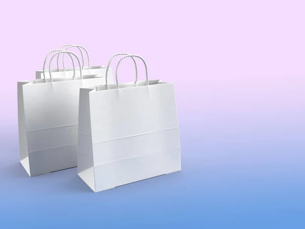 Drei weiße papierverkabelte Einkaufstaschen-Attrappen in einem weiß-blauen Farbverlauf Hintergrund mit einem Raum für Text — Stockfoto