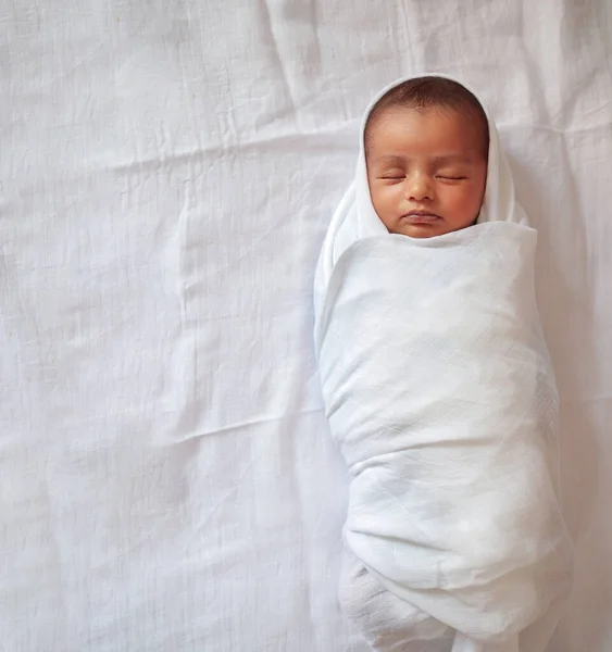 En månad gammal baby sova och lindade i vit duk som ligger i vit duk bakgrund — Stockfoto