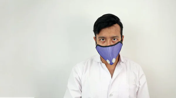 Um profissional médico do sexo masculino em casaco branco e máscara em fundo branco. imagem conceitual para a precaução da infeção viral — Fotografia de Stock