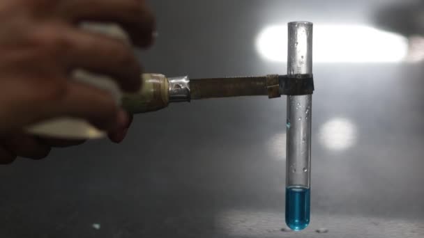 Flüssige Chemikalie aus einem Spender für Plastikwaschflaschen in ein blaues Reagenzglas im Chemielabor gießen — Stockvideo