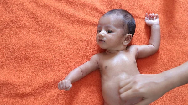 Yetersiz beslenmiş bebek turuncu kadife kumaş arka planda duran kameraya bakıyor. Metin için alanı olan protein enerjisi yetersiz beslenme konsepti