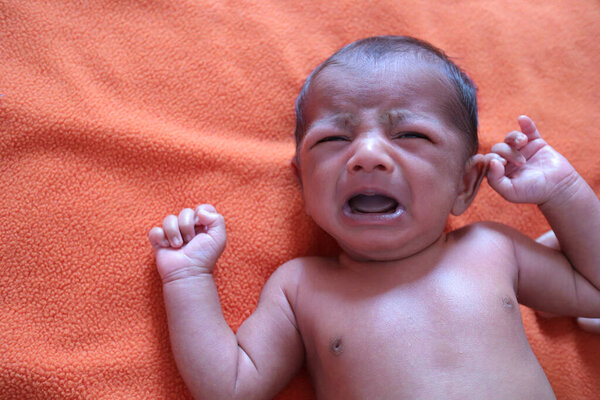 an infant crying in pain and distress