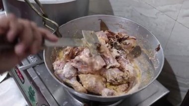 Mutfakta tavuk biryani sosu hazırlarken kızarmış soğanlı çiğ tavuk.