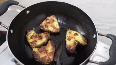 Mutfaktaki tavada çiğ balık kızartma.