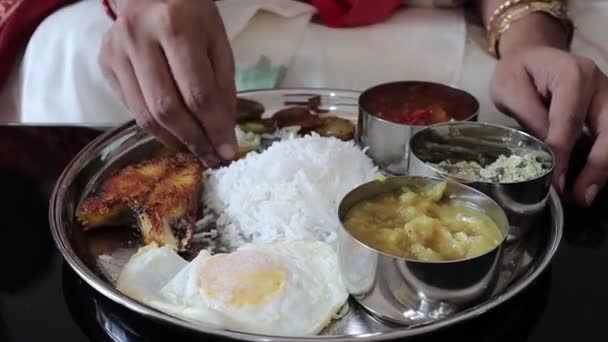 Zblízka záběr na ruce jíst non vegetariánské indické thali s rýží a rybami a dal — Stock video