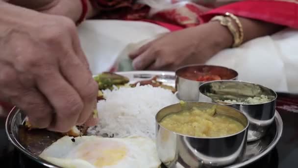 Close up shot on a hand eat a non vegeterian thali with rice and fish and dal — Stok Video