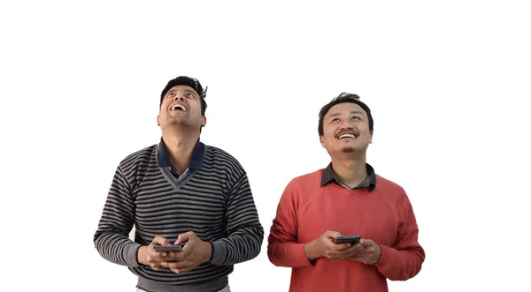 Dois homens com etnia diferente olhando para cima em alegria e sorrindo com o telefone na mão isolado em fundo branco com espaço de cópia para texto — Fotografia de Stock