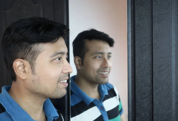 Мужчина и его взгляд в зеркало в счастливом настроении — стоковое фото