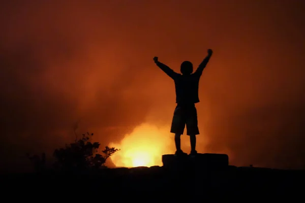 Child celebrates achievement of reaching the summit of the crater rim of Klauea overlook at Volcanoes National Park, Hawaii Big Island.