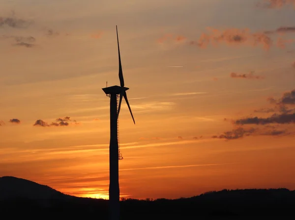 Wind power station in sunset. Romantic evening and modern technologies of ecologically clean electricity. Protection of the environment. Bright Future. An alternative way of extracting energy.