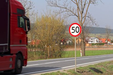 Trafik hız 50 km/h. için sınırlama yol karayolu üzerinde oturum açın. trafik güvenliği. Motorlu ulaşım yolcu ve yükleri. Modern arabalar. Büyük bir kamyon yol boyunca hareket ediyor.
