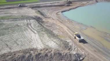 Vislock Nehri, Polonya - 2 Mayıs 2018:A damperli kamyon toprak ile yüklenir. Kara Nehir çakıl ocağında çalışıyor. Doğal kaynakların çıkarılması. Buldozer Cat formları tarafından üretilen bir manzara