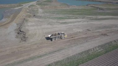 Vislock Nehri, Polonya - 2 Mayıs 2018:A damperli kamyon toprak ile yüklenir. Kara Nehir çakıl ocağında çalışıyor. Doğal kaynakların çıkarılması. Buldozer Cat formları tarafından üretilen bir manzara