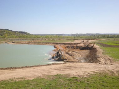 Vislock Nehri, Polonya - 2 Mayıs 2018: Ekskavatör damperli kamyon toprak ile yükler. Kara Nehir çakıl ocağında çalışıyor. Doğal kaynakların çıkarılması. Kedi tarafından üretilen özel bir teknik çalışma