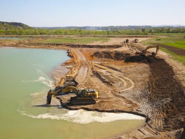 Vislock Nehri, Polonya - 2 Mayıs 2018: Ekskavatör damperli kamyon toprak ile yükler. Kara Nehir çakıl ocağında çalışıyor. Doğal kaynakların çıkarılması. Kedi tarafından üretilen özel bir teknik çalışma