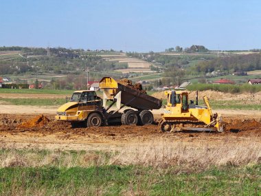 Vislock Nehri, Polonya - 2 Mayıs 2018: Ekskavatör damperli kamyon toprak ile yükler. Kara Nehir çakıl ocağında çalışıyor. Doğal kaynakların çıkarılması. Kedi tarafından üretilen özel bir teknik çalışma