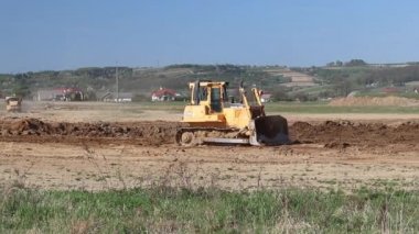 Vislock Nehri, Polonya - 2 Mayıs 2018:A damperli kamyon toprak ile yüklenir. Buldozer nehir çakıl ocağı earthland eserlerinde eşittir. Doğal kaynakların çıkarılması. Kedi tarafından üretilen bir buldozer