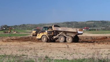 Vislock Nehri, Polonya - 2 Mayıs 2018:A damperli kamyon toprak ile yüklenir. Kara Nehir çakıl ocağında çalışıyor. Doğal kaynakların çıkarılması. Buldozer Cat formları tarafından üretilen bir manzara