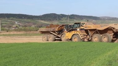Vislock Nehri, Polonya - 2 Mayıs 2018:A damperli kamyon toprak ile yüklenir. Kara Nehir çakıl ocağında çalışıyor. Doğal kaynakların çıkarılması. Buldozer Cat formları tarafından üretilen bir manzara