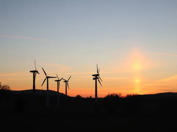 Wind power station in sunset. Romantic evening and modern technologies of ecologically clean electricity. Protection of the environment. Bright Future. An alternative way of extracting energy.