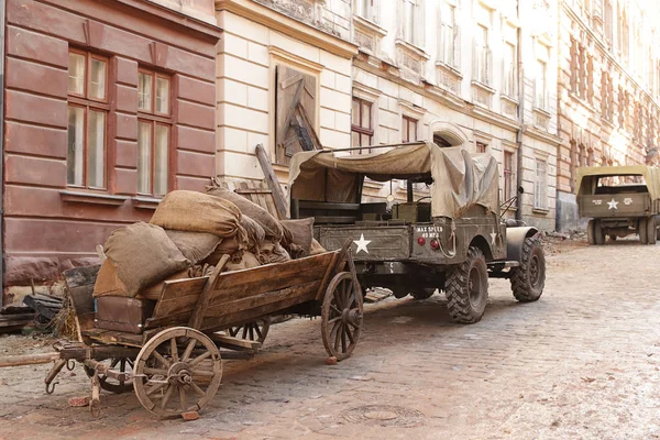 Lviv, Oekraïne - 9 9 2019: Amerikaanse auto 's in een door oorlog verwoeste straat. Landschap voor de Holocaust speelfilm tijdens de Tweede Wereldoorlog. Hete plekken van militaire conflicten. Amerikaanse troepen in Europa — Stockfoto
