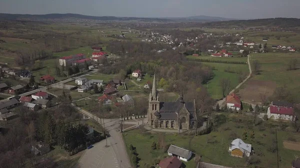 Cieklin, Pologne - 4 9 2019 : Panorama d'un petit village européen avec une église catholique chrétienne au centre. Fermes au milieu de collines verdoyantes pittoresques. Panorama de la région des Carpates avec un drone — Photo