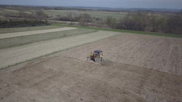 Un agriculteur sur un tracteur avec un semeur sème du grain dans une terre labourée dans un champ privé dans la région du village. Mécanisation des travaux sur le terrain. La vie quotidienne du fermier. Traitement des terres. L'agraire .