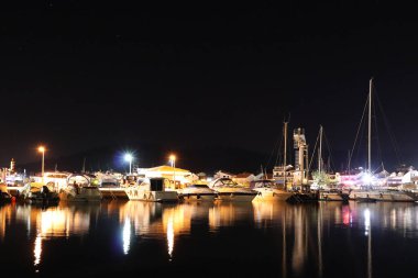 Night parking of yachts in the Croatian ACI marina of the town of Jazira. Burning lights of the evening Mediterranean port with sailing yachts and fishing boats. Twilight on the Adriatic Riviera. Calm