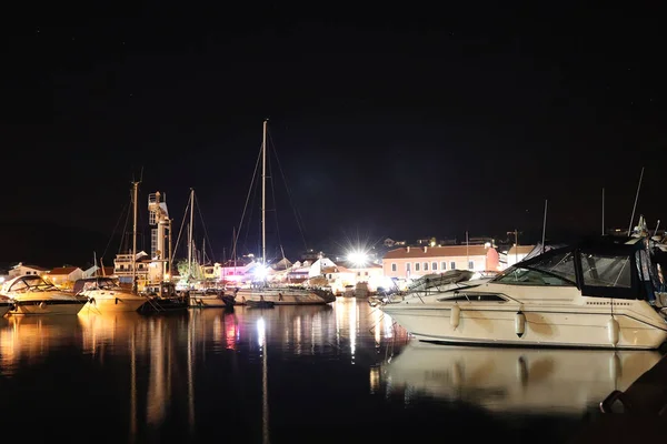 Night parking of yachts in the Croatian ACI marina of the town of Jazira. Burning lights of the evening Mediterranean port with sailing yachts and fishing boats. Twilight on the Adriatic Riviera. Calm — 图库照片