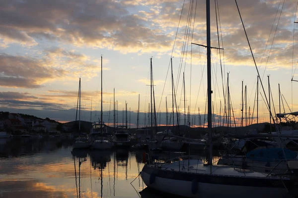 Sunset in the Croatian marina of the ACI of the town of Jazira. Burning lights of the evening Mediterranean port with sailing yachts and fishing boats. Twilight on the Adriatic Riviera. Calm rest — 图库照片